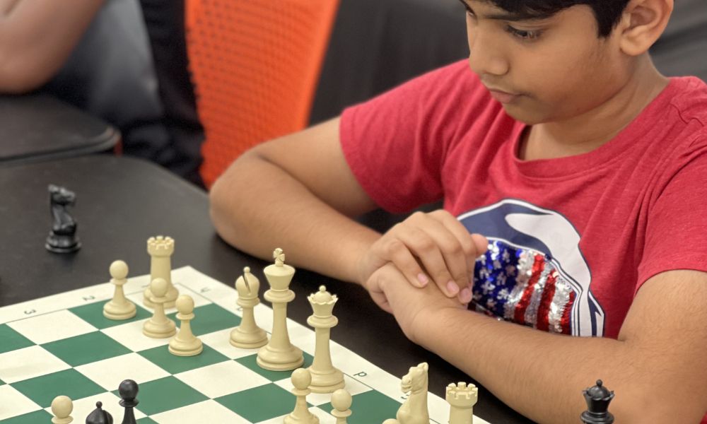 A young CHESSKLUB student ready to play a chess game.