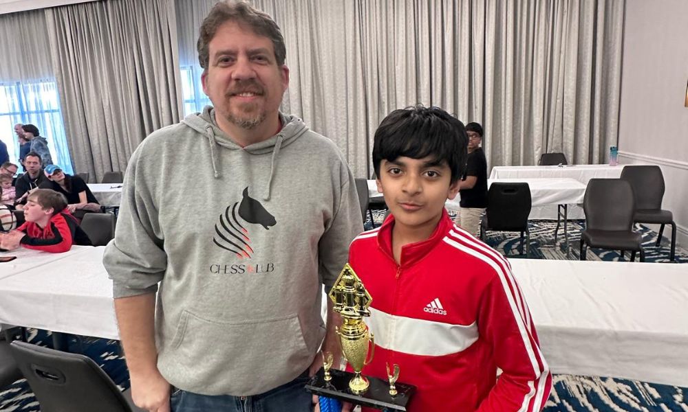 CHESSKLUB student and coach celebrating progress after a successful chess game.